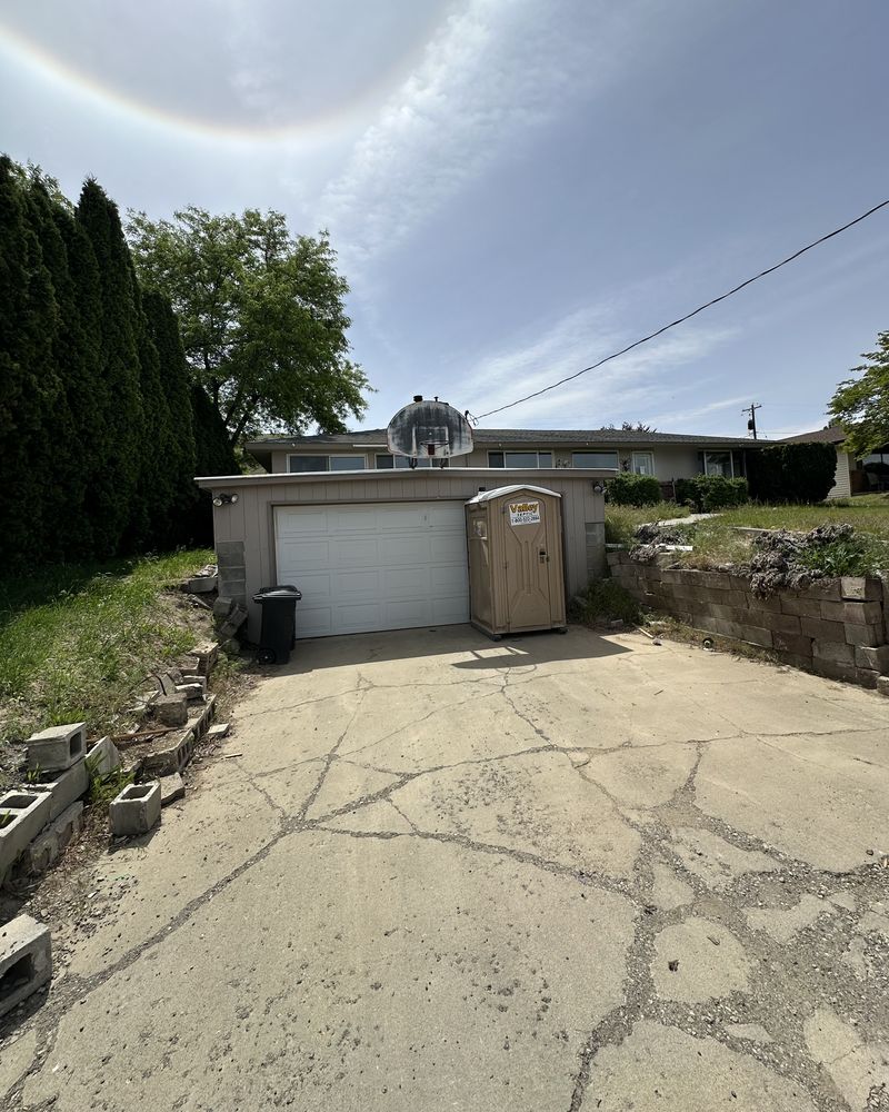 Another house: the driveway and garage, before: cracked concrete, broken blocks and weeds